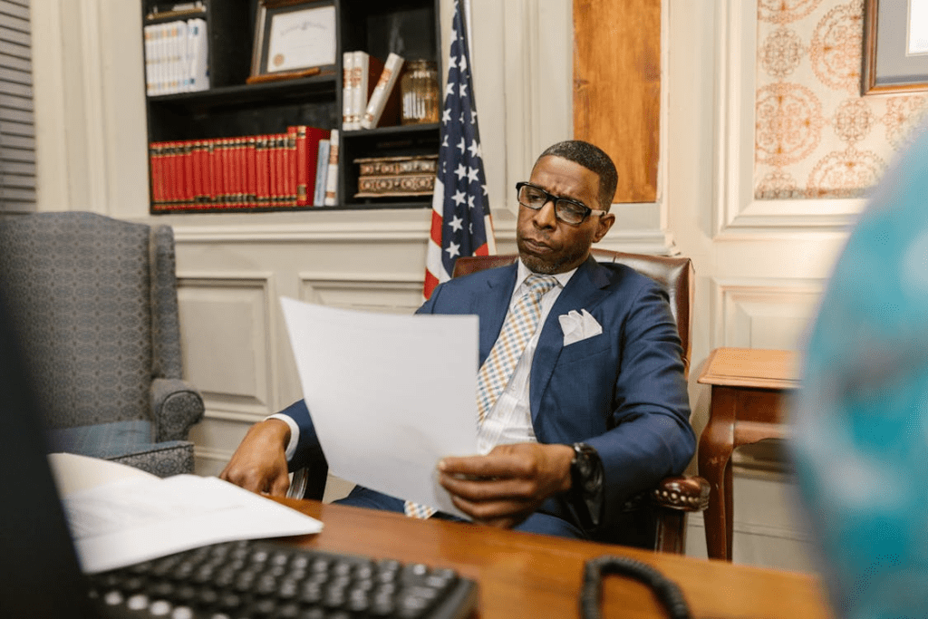 Attorney sitting at a desk in a professional law office reviewing a compensation offer letter