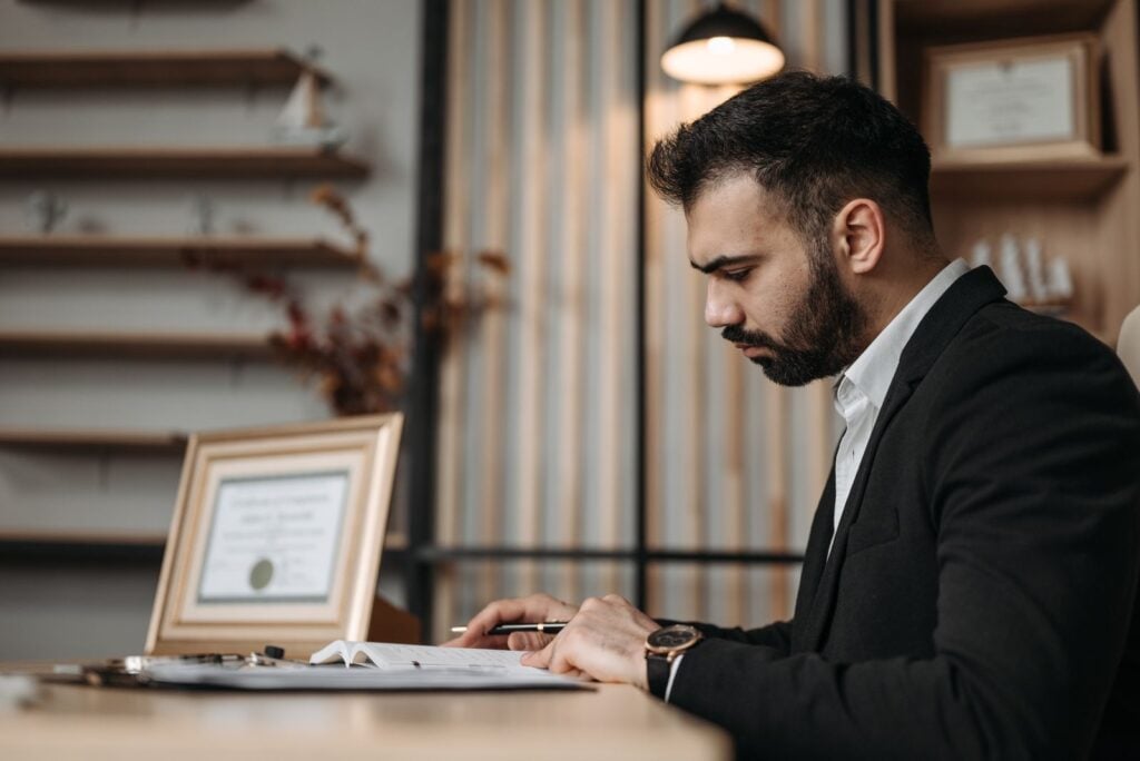 Corporate attorney reviewing contracts at desk